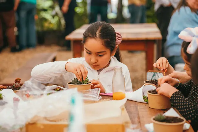 Niña plantando en un taller